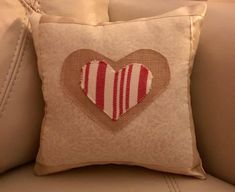 a pillow with a heart on it sitting on a couch