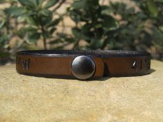 This custom infinity BRACELET is hand tooled and stained with a lovely antique medium brown that seems to glow in the sunlight, or another stain of choice. This bracelet is 1/2 inch wide and has a very durable metal snap holding it together. In the center of the bracelet is an infinity symbol, please note with your order if you desire it to be placed in another area on the cuff. It can be made with a name and/or date, coordinates, special text (the Character amount is below) or whatever you wish Brown Leather Bracelet With Engraving Option, Adjustable Brown Leather Bracelet Gift, Distressed Brown Leather Bracelet Gift, Adjustable Vintage Brown Bracelets As Gift, Adjustable Vintage Brown Bracelet As Gift, Adjustable Vintage Brown Bracelet For Gift, Adjustable Vintage Brown Leather Bracelet As Gift, Adjustable Vintage Brown Leather Bracelet Gift, Adjustable Vintage Brown Leather Bracelet