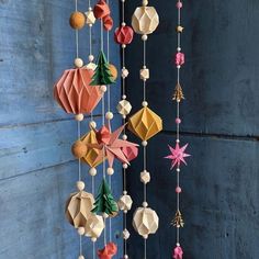 an origami mobile is hanging on the wall with other ornaments attached to it