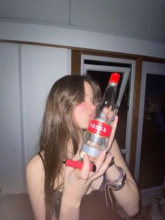 a woman holding a bottle of vodka in her hand