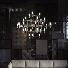 a living room filled with furniture and a chandelier hanging over the top of it