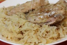 a white plate topped with meat and sauerkraut