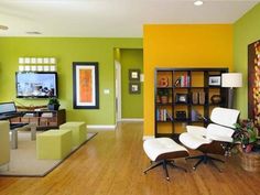 a living room with green walls and white chairs in the center, yellow accent wall