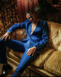 a man in a blue suit sitting on a couch