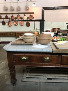 an old kitchen with pots and pans hanging on the wall