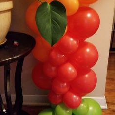 a bunch of balloons that are sitting on the ground next to a table and chair