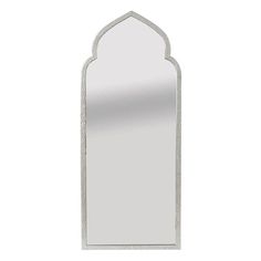 a mirror that is sitting on top of a white wall mounted shelf with an arched design