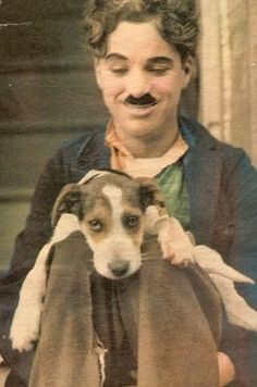 an old photo of a woman holding a dog with a mustache on it's head