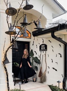 a woman standing in the doorway of a house decorated for halloween with bats and lights