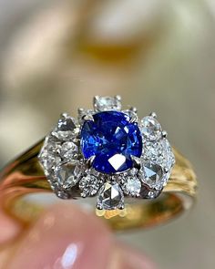 a blue and white diamond ring sitting on top of a table