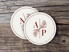 two round business cards with the letter aap on them sitting on a wooden surface