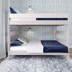 two bunk beds with blue and white bedding in front of a patterned wallpaper