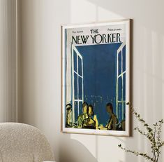 a poster hangs on the wall next to a chair and vase with flowers in it