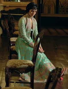 Indulge in timeless elegance with this classic kalidar anarkali set, crafted from firozi green jacquard silk banarasi. Featuring intricate zari and zardozi embroidery, enhanced with dabka, sequins, and pearls for added depth and richness, this design is truly captivating. The ensemble is completed with a cropped jacket adorned with sequins and delicate pearl tassels, while a signature embellished belt ensures a gracefully defined silhouette. Anarkali Style Bandhgala With Resham Embroidery, Designer Anarkali Sherwani In Pista Green, Green Meenakari Anarkali Set For Reception, Chanderi Meenakari Anarkali Set For Reception, Reception Meenakari Chanderi Anarkali Set, Meenakari Chanderi Anarkali Set For Reception, Anarkali Meenakari Set For Reception, Pista Green Anarkali Set With Meenakari, Designer Raw Silk Anarkali Set With Meenakari