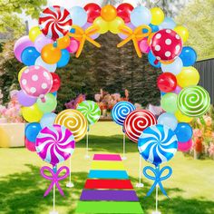 an arch decorated with balloons and lollipops