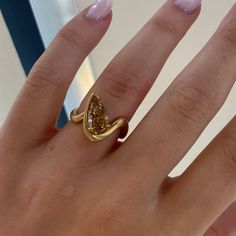 a woman's hand with a yellow diamond ring on top of her left hand