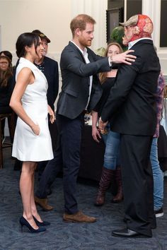 a man in a suit and tie shaking hands with other people