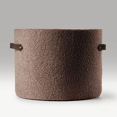 a large brown pot sitting on top of a white table