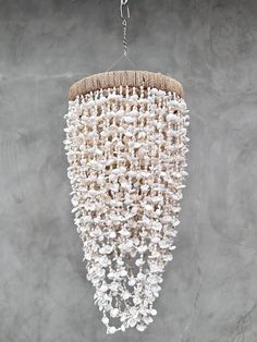 a white chandelier hanging from the ceiling with beads and shells attached to it