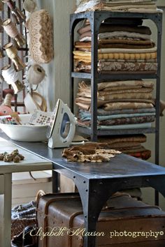 an old ironing board with many pieces of cloth on it in front of a table