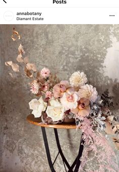 a table with flowers on it in front of a wall and an advertise