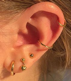 a close up of a person's ear with three different piercings