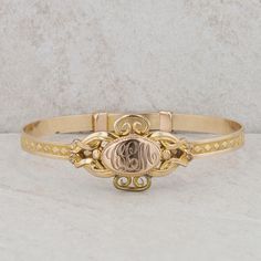 This children's gold plated bangle features an oval shaped monogram at its center, accented by filigree detailing, along with a diamond pattern around the rest of the bracelet. At the center, the initials "CLM" are engraved. This bracelet design is an adjustable to put on the wrist but it can only be worn at 5" inches. The bangle weighs 10.20 grams and measures in height 19.5mm. It can also be on a smaller ladies wrist but due to the size, it would more than likely be for a smaller child. Condit Classic Gold Bracelet With Intricate Design, Classic Bracelets With Decorative Band For Formal Occasions, Classic Gold Bracelet With Intricate Design For Anniversary, Classic Gold Bangle Bracelet With Intricate Design, 14k Gold Bracelets With Intricate Design For Anniversary, Elegant 14k Gold Bracelets With Decorative Band, Classic 14k Gold Bracelets With Intricate Design, Classic Cuff Bracelet With Intricate Design For Anniversary, Classic Gold Bangle With Intricate Design