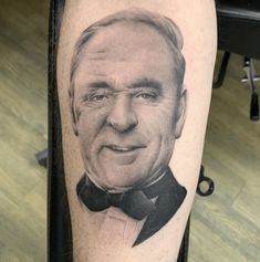 a man's leg with a portrait of an older gentleman on it and a bow tie around his neck