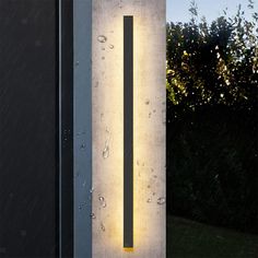 a light that is on the side of a building with water droplets all over it