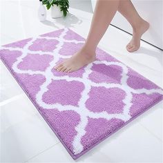 a woman's feet on a pink rug in the bathroom