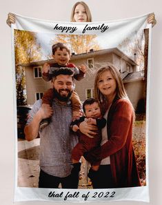 a family photo hanging on a wall in front of a house with the words happy family