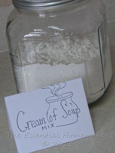 a glass jar filled with white sand next to a label that says cream of soup mix