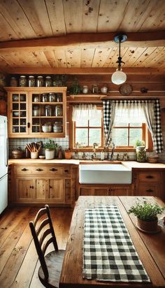 a kitchen with wooden walls and flooring next to a dining table in front of a window