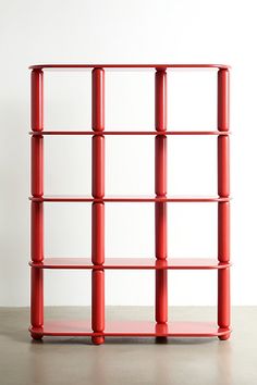 a red shelf sitting on top of a cement floor