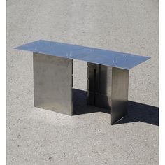 a metal table sitting on top of a cement ground