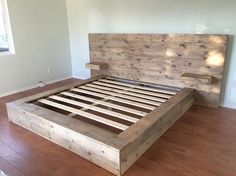 a bed frame made out of wooden planks in a room with hard wood flooring