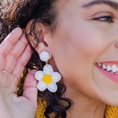 These Beaded White Daisy Earrings are the perfect way to radiate happiness and sunshine! All white with a yellow center, our daisies symbolize new beginnings and are perfect for a new school year or season in your life! These earrings are lightweight and comfortable for all-day wear. Details: Super lightweight at just 0.3 ounces Measures approximately 1 1/2 inches wide x 2 inches long Post backing Nickel-free Reverse side is a felt lining Daisy Flower Earrings For Spring, Spring Daisy Flower Earrings, White Daisy Flower Earrings For Spring, White Flower Beaded Earrings For Spring, White Beaded Earrings For Spring, Trendy White Beaded Earrings For Summer, Handmade White Beaded Earrings For Spring, Adjustable White Flower Earrings For Spring, Cute White Flower Earrings For Spring