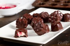 some chocolates are on a white plate and one is half filled with red velvet