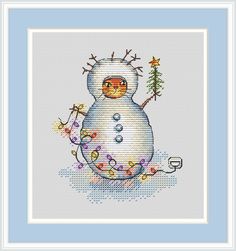 a cross stitch snowman with a mug in his hand and christmas lights around it