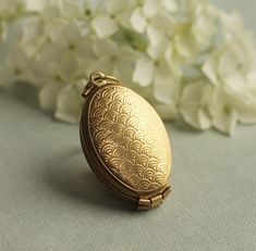 a gold locke sitting on top of a table next to white flowers