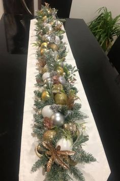 a long table is decorated with ornaments and greenery