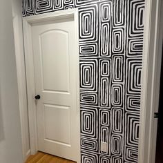 an open door in a room with black and white wallpaper