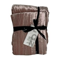 a blanket wrapped in velvet with a black ribbon around it and a tag on the front