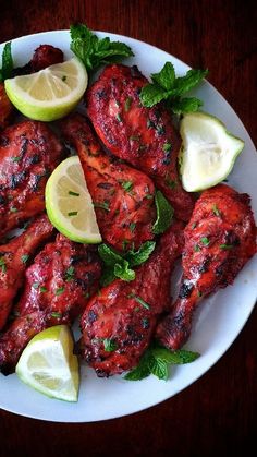 chicken wings with lemon and mint garnish on a white plate