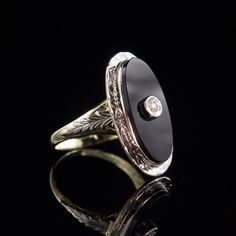 Metal: Solid 14k Yellow and White Gold Stone: 9x18 mm Onyx and a 2mm Diamond Size: 5 Weight: 3.7 grams Era: 1930's This classy ring is white gold on the top and yellow gold on the bottom. Intricately engraved white gold leaves adorn each side of the ring. The oval onyx has a small diamond set in white gold in the center. All of the engraving is still crisp and detailed after all these years. The stone is in very good condition with no eye visible flaws. The interior of the band is stamped with the 14k gold purity stamp. The ring has been professionally cleaned and polished and is ready to wear.  To view our other listings of fine jewelry click here, https://www.etsy.com/shop/seafarevintage?ref=hdr_shop_menu To help make your decision easier, I am always more than happy to take additional p Elegant Platinum Signet Ring With Polished Finish, Oval White Gold Jewelry With Black Enamel, Antique Engraved Ring With Polished Finish For Formal Occasions, Victorian Oval Engraved Diamond Ring, Victorian White Gold Signet Ring For Formal Occasions, Victorian Engraved Oval Diamond Ring, Oval Rings With Polished Finish For Evening, Victorian Style Engraved Ring With Polished Finish, Victorian Style Engraved Oval Diamond Ring