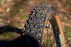 the tire of a bicycle is seen in this close up photo, with grass and dirt behind it