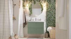 the bathroom is decorated with greenery and white tile walls, along with a wooden vanity