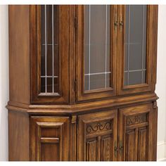 a wooden china cabinet with glass doors on the front and side panels inlays