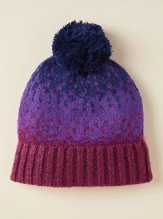 a purple and blue knitted hat with pom - pom