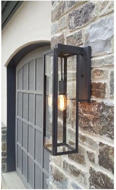 a light that is on the side of a building next to a door and some bricks